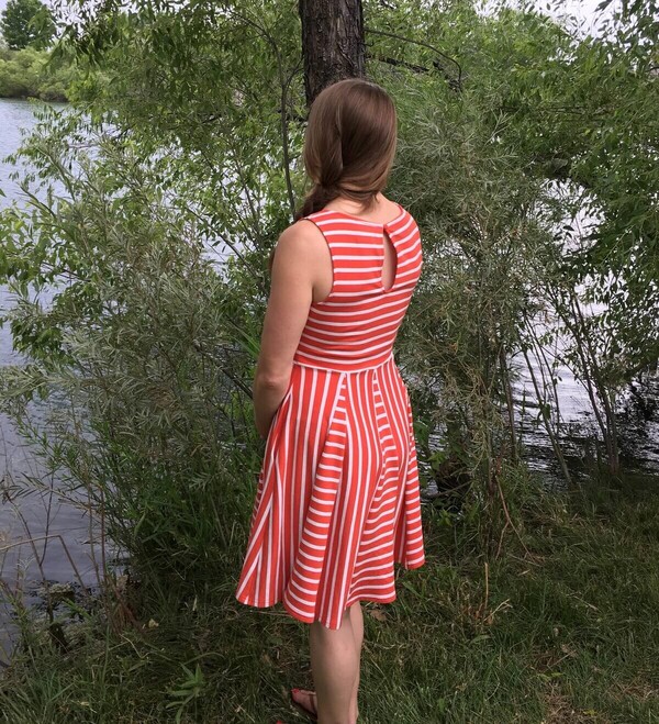 A woman standing by a pond.