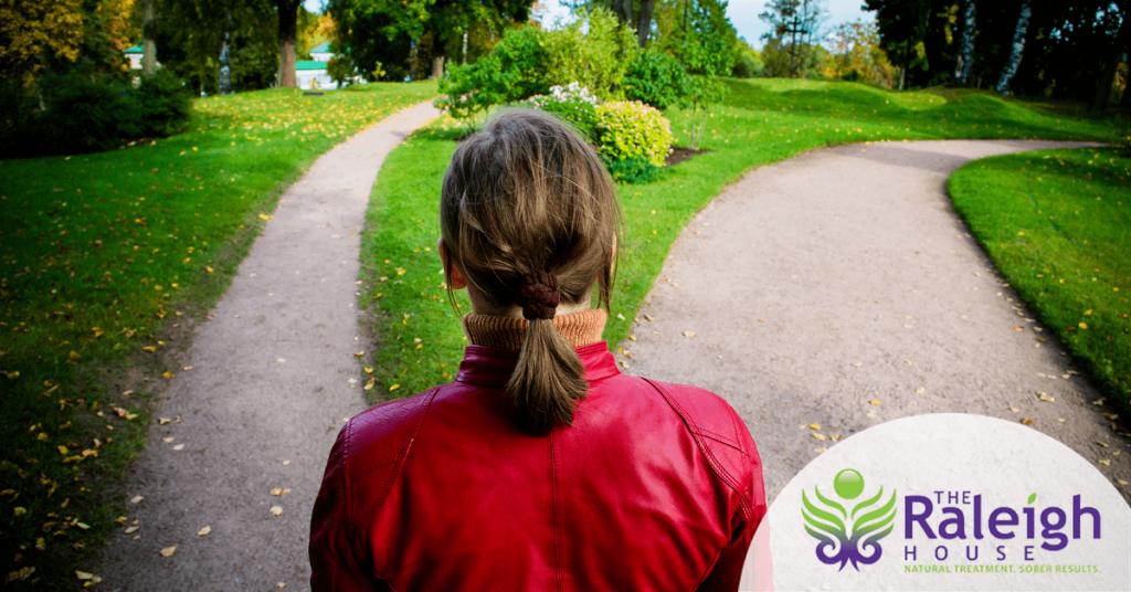 A young adult stands at a fork in the road to recovery. The question? Inpatient alcohol rehab or outpatient?