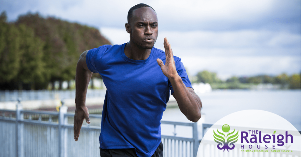 A fit man jogs down a boardwalk.