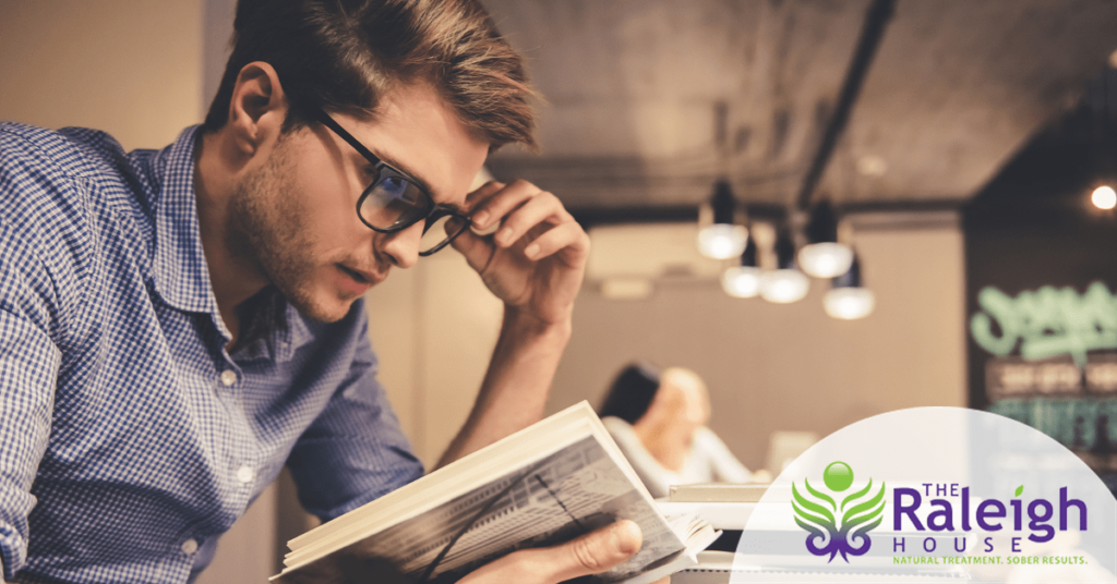 A young man concentrating on his text book as he studies