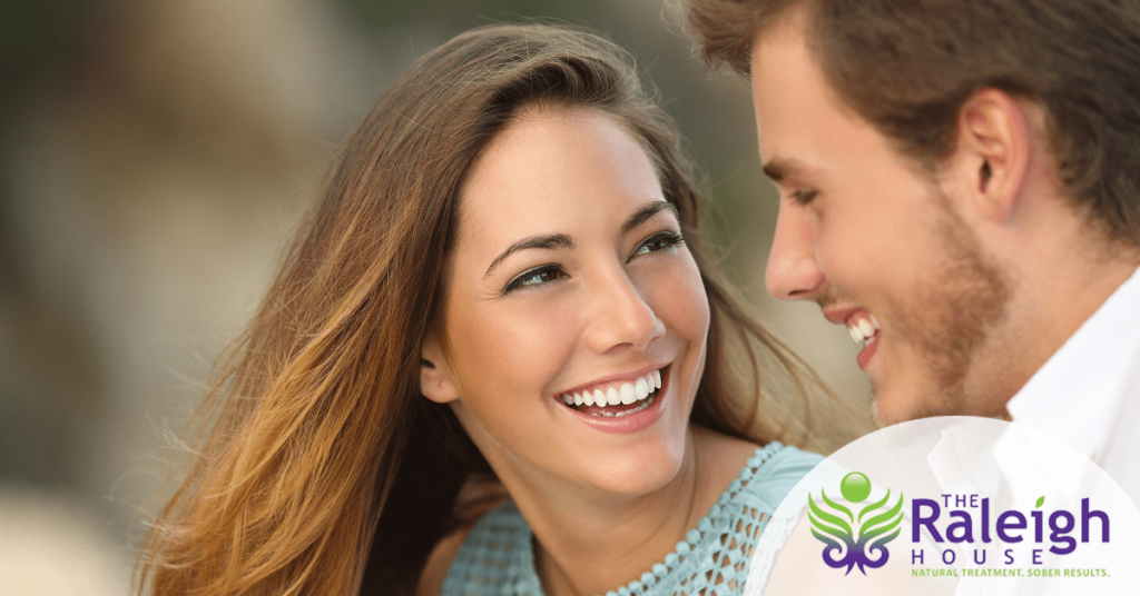 A young couple smiles and laughs together.