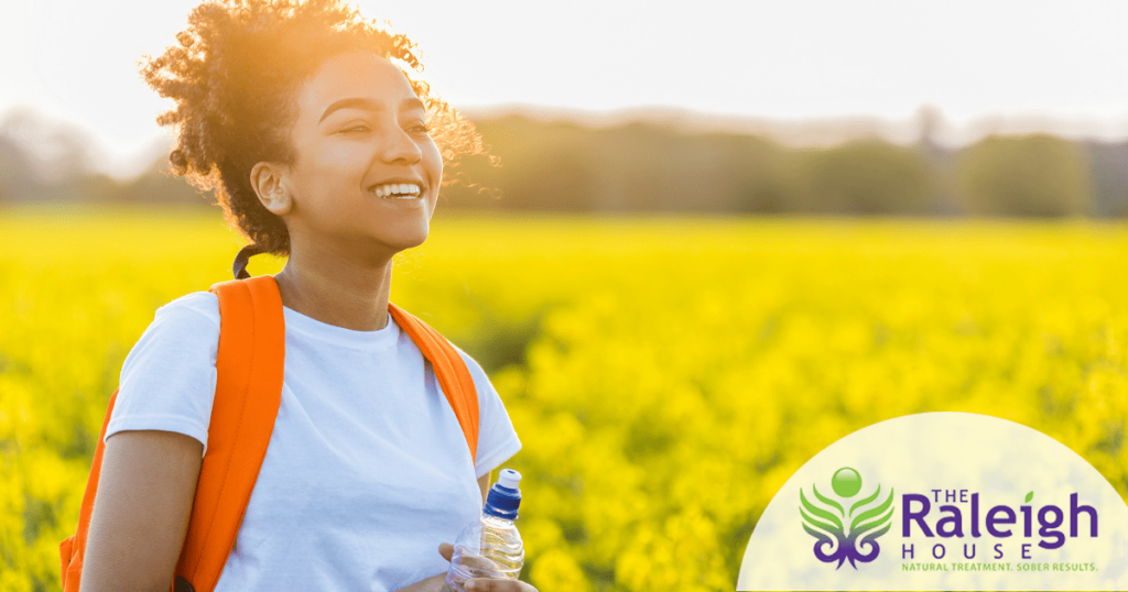 A young woman takes a break on a hike and enjoys the beautiful view