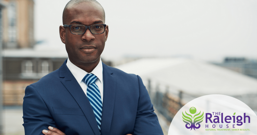 A portrait of a successful young businessman standing with his arms crossed outside his office.