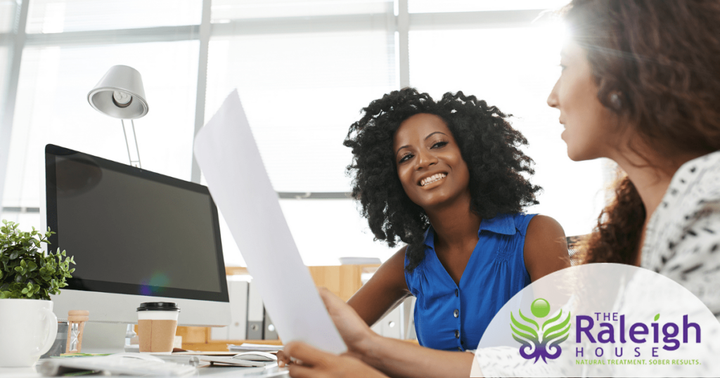 Two happy women work together in an office