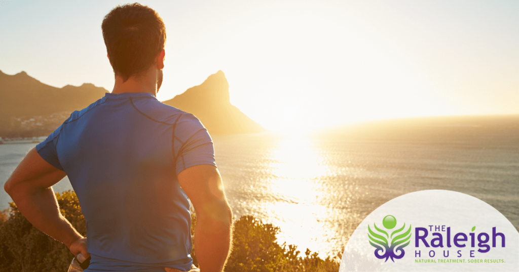 A young man takes a break during his hike to watch the sun set