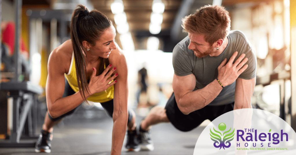 A young man and woman workout at a gym.