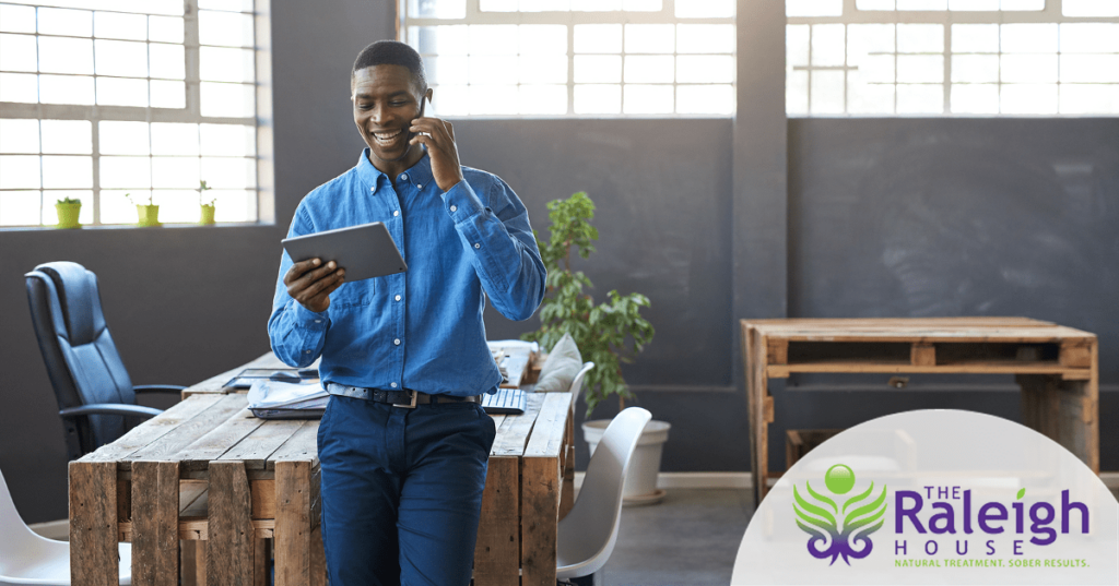 A young businessman looks at a tablet in his office.