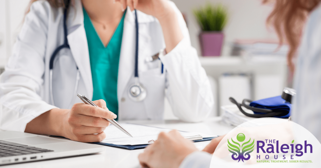 A close up view of a doctor speaking across a desk from her patient and talking.