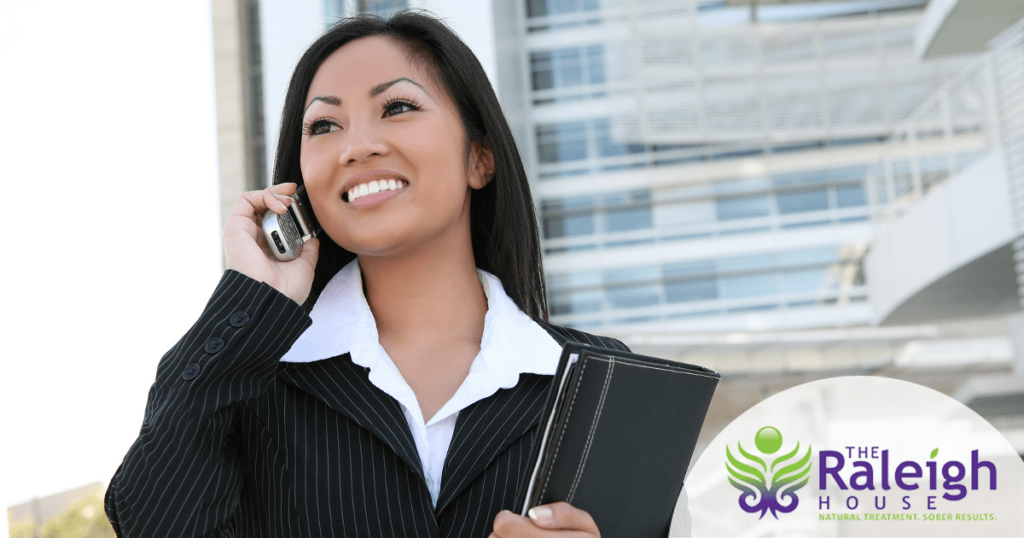 A young business woman talks on the phone.