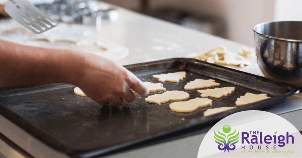 A man takes a tray of cookies out of the oven.