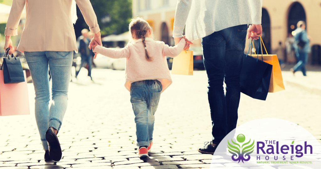 A couple and their grown children take a walk in the park together.