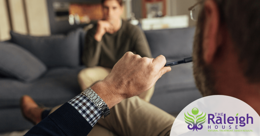 An addiction counselor speaks to a young man during a private therapy session. 