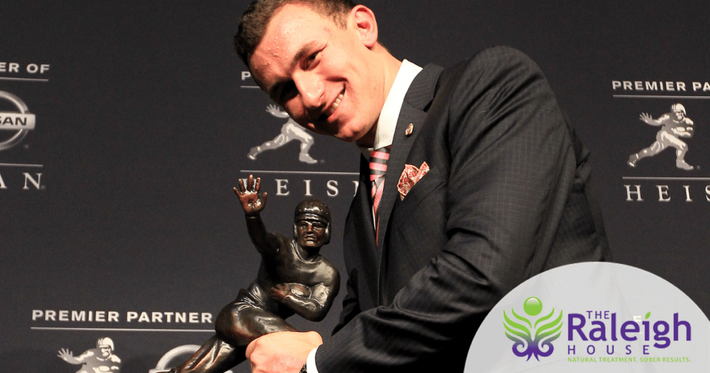 Johnny Manziel holding his Heisman Trophy at the ceremony where he was awarded the honor.