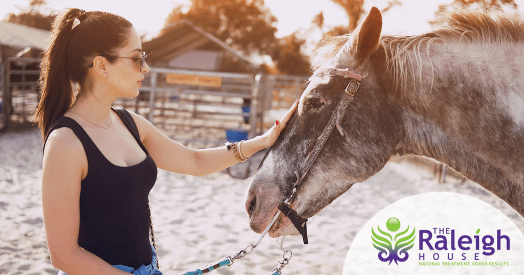 A woman pets a horse.