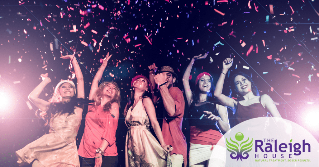 A group of young adults dance as confetti falls down.