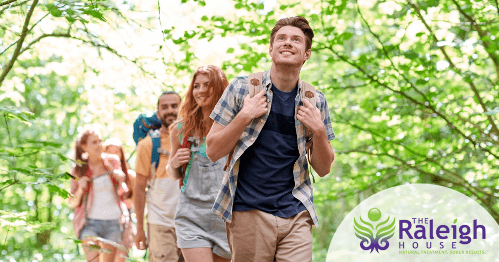 A group of four young adults goes for a hike as they discuss sober activities.