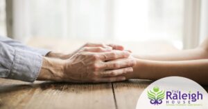Man and child holding hands across a table