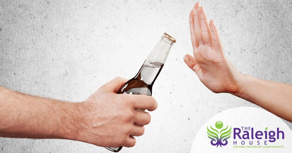 A hand refusing to take a beer bottle
