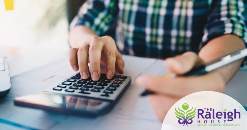 A close-up shot of a man crunching numbers on a calculator.