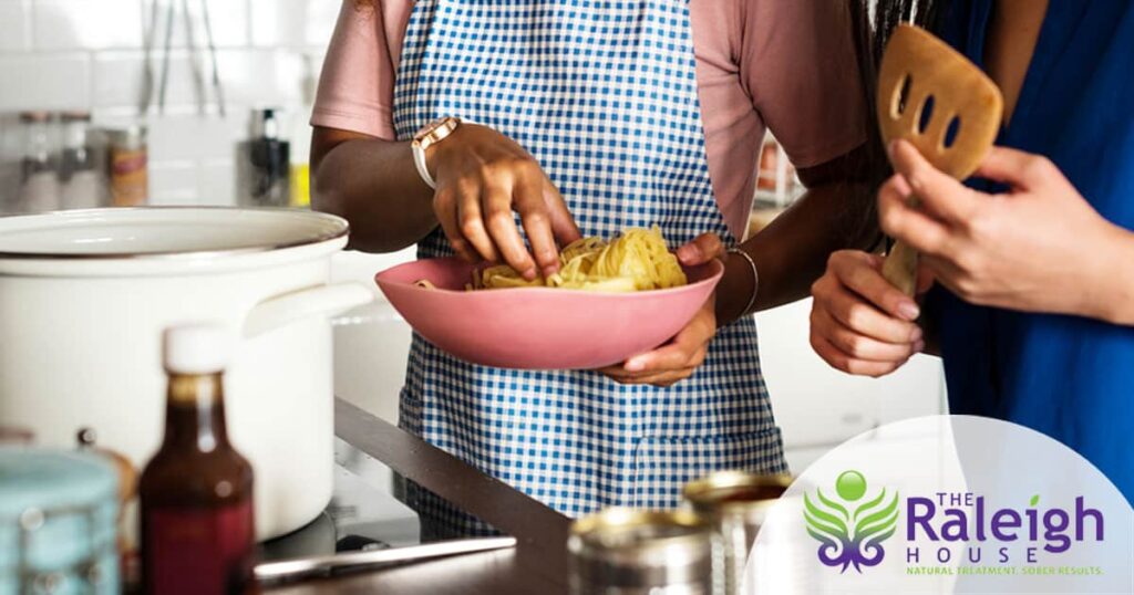A close-up view of two women cooking together in a kitchen.