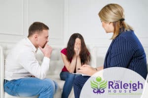A husband supporting his wife during an addiction treatment therapy session.