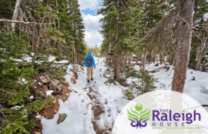 A man hiking along a snowy trail in Rocky Mountain National Park in Colorado.