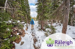 A man hiking along a snowy trail in Rocky Mountain National Park in Colorado.