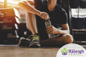 Man on the floor opening a water bottle