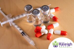 A close up of morphine vials, syringes and pills.