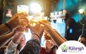 A group of friends toasting their beers at a bar on St. Patrick’s Day.