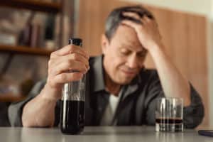A man struggling with alcohol addiction, unknowing of the effects drinking has on his immune health.