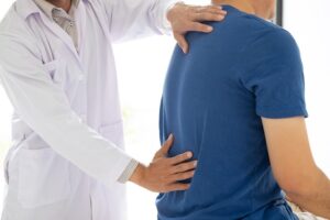 A man consulting a doctor because of chronic back pain.