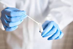 A scientist using cheek swab samples to do genetic testing for addiction.