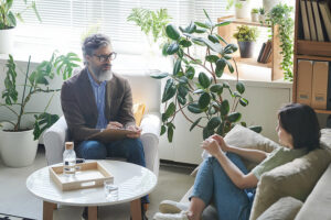 An addiction treatment professional conducting a therapy session with a woman recovering from substance abuse.