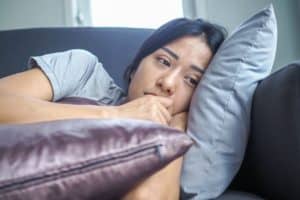 A woman struggling with depression lying on the couch. 