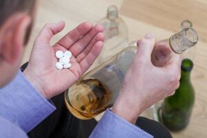 A man mixing psychiatric drugs with alcohol at home.