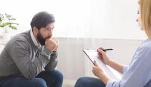 A man with PTSD talking to his therapist.