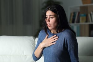 A woman having an anxiety attack at home on her couch.