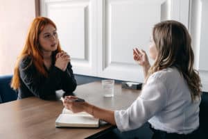 A woman talking to a therapist in mental health treatment.