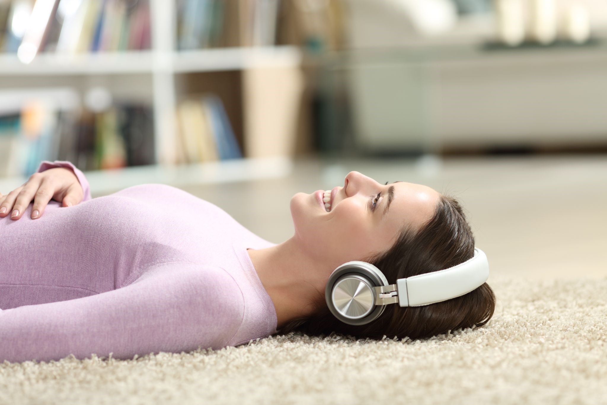 A woman relaxing while listening to music at home.