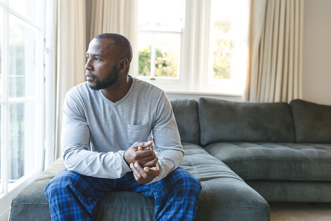 Man sitting on a couch looking out a window