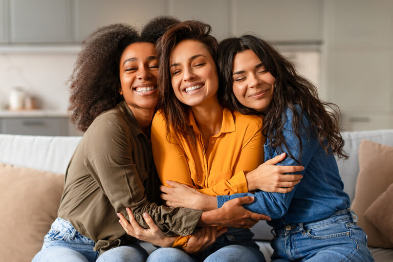 three young women hugging each other in support