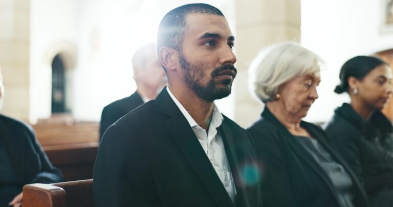 Sad, man and face closeup with depression at a funeral in church for religious service and mourning.