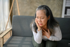 woman holding her chest with worried expressioon