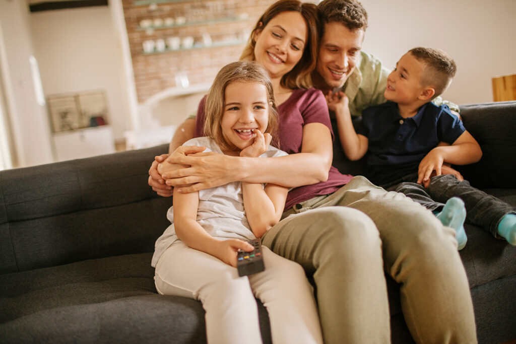 Happy young family sitting on couch together