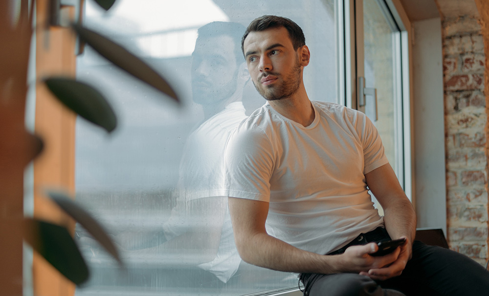 young man looking out window