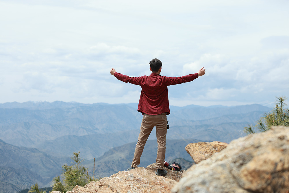 A man stands on a large rock