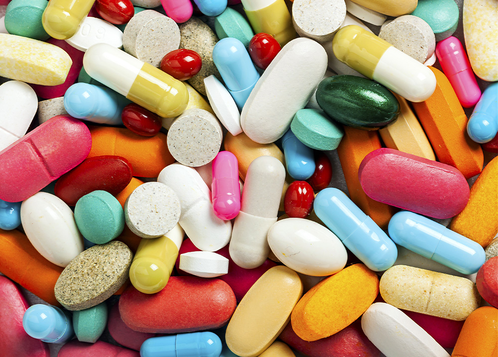 An assortment of brightly colored pills on a table.